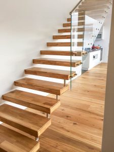 Treppe mit Trittstufen aus Eichenholz und Glasgeländer