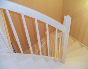 Weiß lackierte Treppe mit Trittstufen, Setzstufen und Geländer mit gedrechselten Geländerstäben