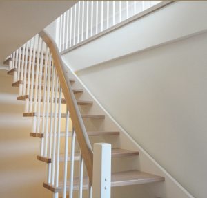 Treppe aus Buchenholz mit weiß lackierten Geländersprossen
