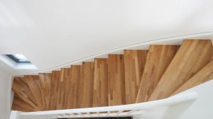 Treppe mit Trittstufen aus Eichenholz und weißen Setzstufen